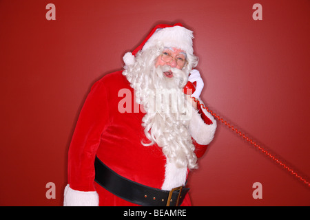 Santa talking on telephone Banque D'Images