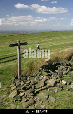 Une dame marcher seule sur la piste de pierre meulière près de Sponds Hill à la nord-ouest vers Stockport et Manchester. Banque D'Images