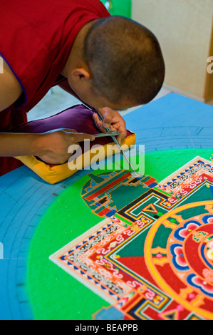 Moine tibétain Yeshi Choedup travaille avec soin sur un mandala de sable coloré dans la région de Ruidoso, Nouveau Mexique. Banque D'Images