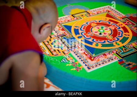 Moine tibétain Tsering VenoDhondup travaille avec soin sur un mandala de sable coloré dans la région de Ruidoso, Nouveau Mexique. Banque D'Images