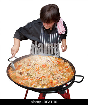 Woman cooking paella dans un grand pan de métal Banque D'Images