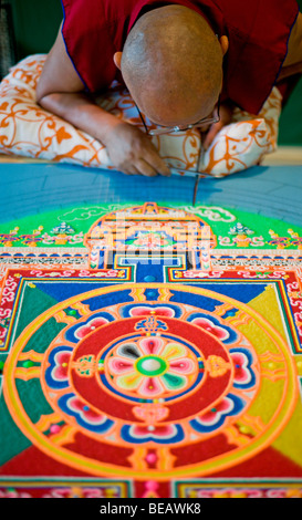 Moine tibétain Tsering VenoDhondup travaille avec soin sur un mandala de sable coloré dans la région de Ruidoso, Nouveau Mexique. Banque D'Images