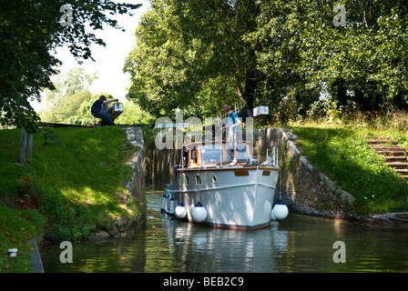 Bateau à moteur en passant par les portes d'écluses à Hungerford sur le canal Kennet et Avon Banque D'Images