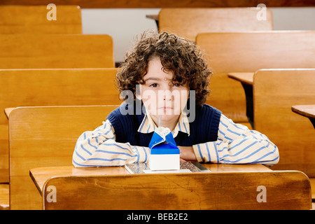 Boire du jus d'écolier dans une salle de classe Banque D'Images