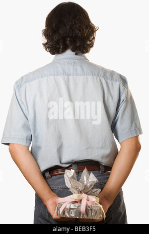 Vue arrière d'un homme se cachant derrière lui un cadeau Banque D'Images