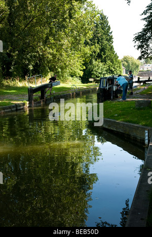 L'homme et la femme pour verrouiller la porte d'ouverture à Hungerford Bateau étroit sur le canal Kennet et Avon Banque D'Images