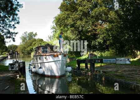 Bateau à moteur en passant par les portes d'écluses à Hungerford sur le canal Kennet et Avon Banque D'Images