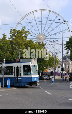 Un tram passant par une grande roue à Zurich Banque D'Images