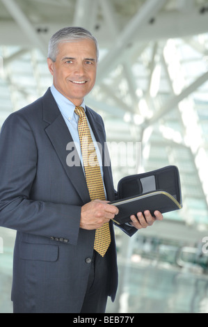 Homme debout avec Planner ordinateur portable dans le bureau Banque D'Images