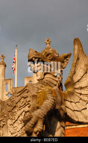 Avec l'Union flag derrière, un gros plan d'une statue de dragon à l'entrée principale de l'établissement Hampton Court Palace, Surrey, UK Banque D'Images