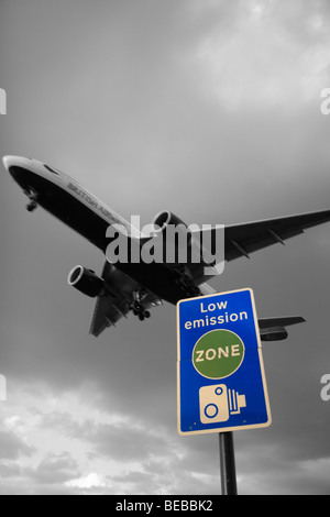 Un areplane British Airways passe au-dessus de 'zone environnementale' road à côté de l'aéroport d'Heathrow à Londres, Royaume-Uni. B&W et mélange de couleurs. Banque D'Images