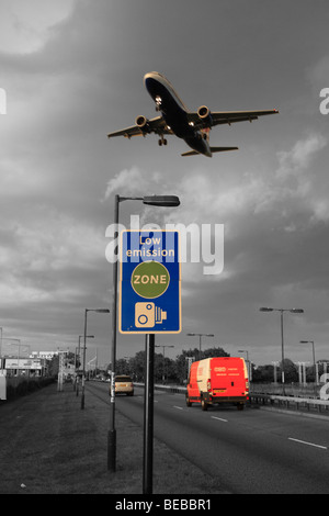 Cars, voitures et avions passant passer une 'zone environnementale' road à côté de l'aéroport d'Heathrow à Londres, Royaume-Uni. B&W et mélange de couleurs. Banque D'Images