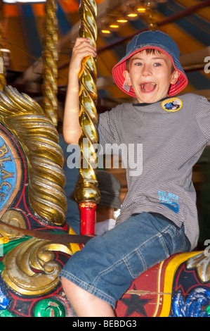 Un jeune garçon se déplace sur le Victorian Gallopers carousel au rond-point Bressingham museum de Norfolk Uk Banque D'Images