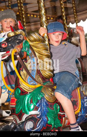 Un jeune garçon se déplace sur le Victorian Gallopers carousel au rond-point Bressingham museum de Norfolk Uk Banque D'Images