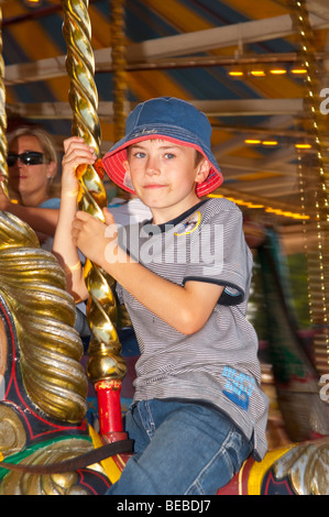 Un jeune garçon se déplace sur le Victorian Gallopers carousel au rond-point Bressingham museum de Norfolk Uk Banque D'Images