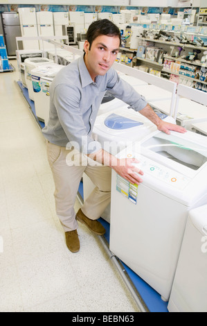 L'homme l'achat d'un lave-linge dans un supermarché Banque D'Images