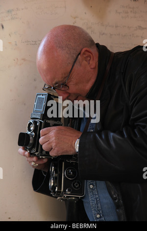 John Minihan tir avec son appareil photo Rolleiflex Banque D'Images