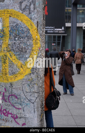 Touriste a sa photographie prise au mur de Berlin, la Potsdamer Platz, Berlin, Allemagne. Banque D'Images