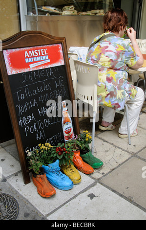 Pavement cafe menu décoré et rempli de chaussures avec des plantes à fleurs. De l'UE Grèce Thessalonique Banque D'Images