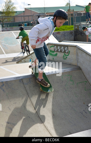 Les garçons avec un skate et vtt, pratiquer sur une rampe Banque D'Images