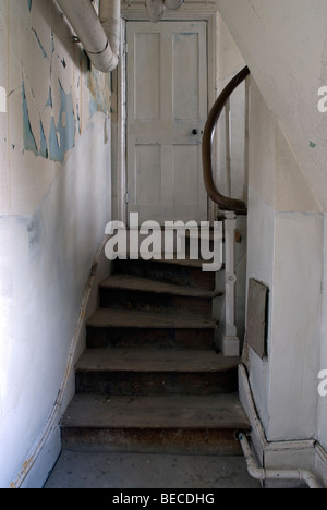 Escalier blanc et porte en bâtiment abandonné avec la chute du mur de peinture Banque D'Images