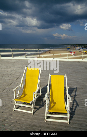 Deux chaises longues jaune sur De Scheveningse Pier, vue sur la plage de Scheveningen, une station balnéaire des pays voisins Banque D'Images