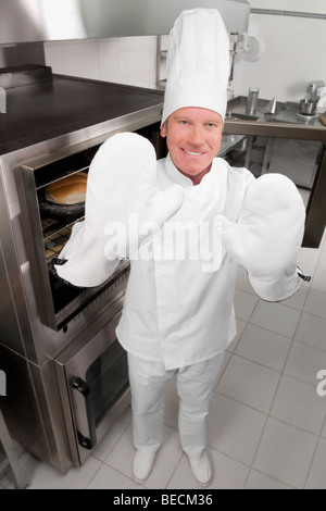 Chef standing in the kitchen and smiling Banque D'Images