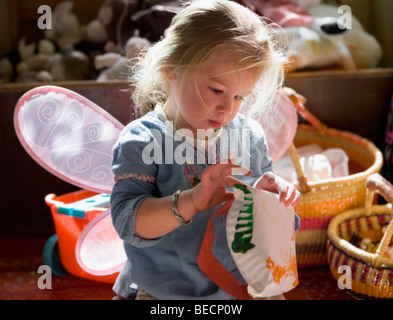 Baby Girl painting une assiette en carton Banque D'Images