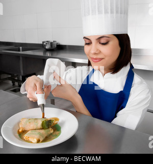 Femme chef de la décoration des pâtisseries et smiling Banque D'Images