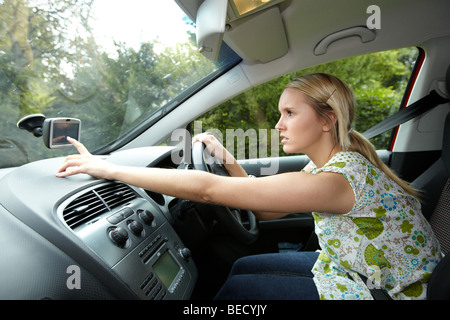 Girl driving car à l'aide de Phone Banque D'Images