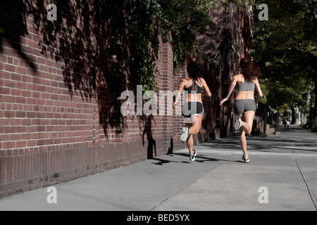 Deux femmes jogging dans une rue Banque D'Images