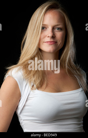 Belle blonde femme en blanc à la recherche dans l'appareil. Banque D'Images