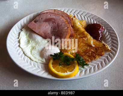 Petit-déjeuner en salle à manger avec des oeufs au plat jambon hash browns orange et ketchup USA Banque D'Images