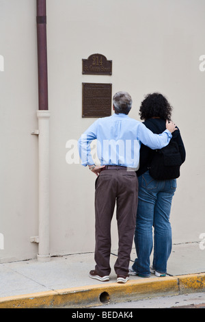 Couple d'âge moyen s'arrêter de lire l'information historique plaque à 214 St George Street dans le centre-ville de Saint Augustine, Floride, USA Banque D'Images