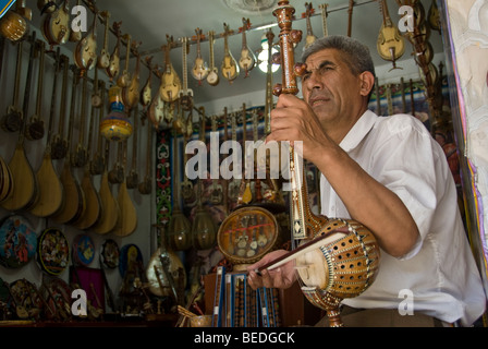 Instrument de musique chinois vendeur dans un marché de Kashgar, Xinjiag Province, Chine 2008. Banque D'Images