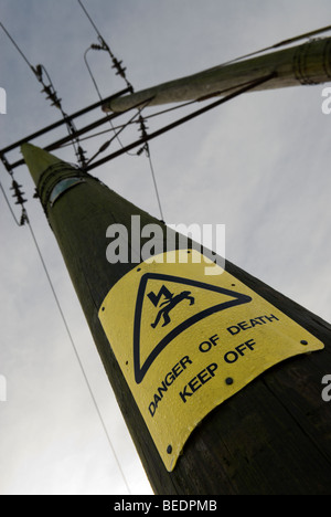 Les signes de danger sur les poteaux des lignes électriques de transport Banque D'Images