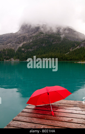 Parapluie rouge avec l'eau du lac Emerald et dock Banque D'Images