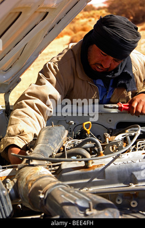 Bedouin homme portant un foulard traditionnel de la fixation d'une voiture, la Libye Banque D'Images