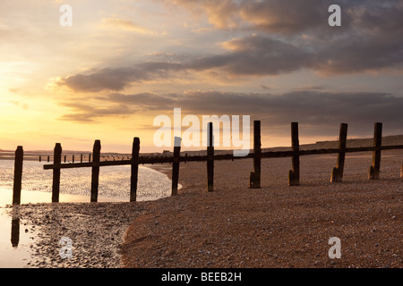 De gros nuages s'asseoir sur bois épis sur la plage de carrossage en Angleterre Banque D'Images