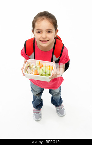 Studio Portrait of Smiling Girl Holding Lunch Banque D'Images