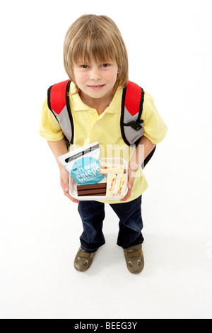 Studio Portrait of Smiling Boy Holding Lunch Banque D'Images