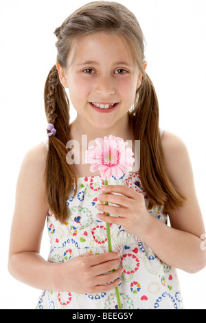 Studio Portrait of Smiling Girl Holding Flower Banque D'Images