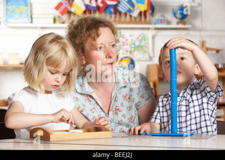 Aider les adultes à deux jeunes enfants au préscolaire/Montessori Banque D'Images