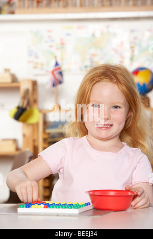 Jeune fille jouant au préscolaire/Montessori Banque D'Images