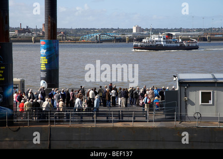 Les touristes et les banlieusards queue à la pier head flottant ferry terminal en attente de la Mersey ferry sur la rivière Mersey Banque D'Images