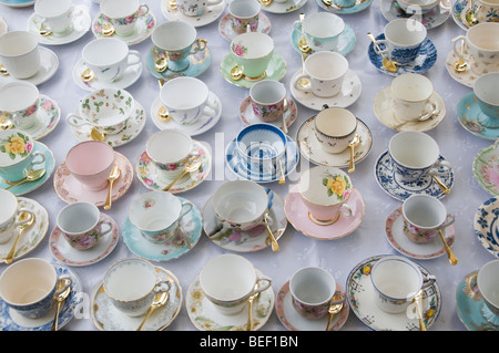 Une table pleine de période différente tasse à thé avec des cuillères à thé de couleur or Banque D'Images