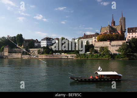 River ferry taxicrossing le Rhin avec Basler Münster cathédrale en arrière-plan sur une journée ensoleillée avec ciel bleu Banque D'Images