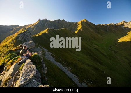 Tôt le matin, un photographe en regardant le "Val de courre' (Auvergne). Photographe admirant le Val de courre au matin. Banque D'Images