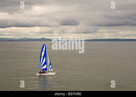 Bateau à voile blanche et bleue dans le Firth of Forth Banque D'Images