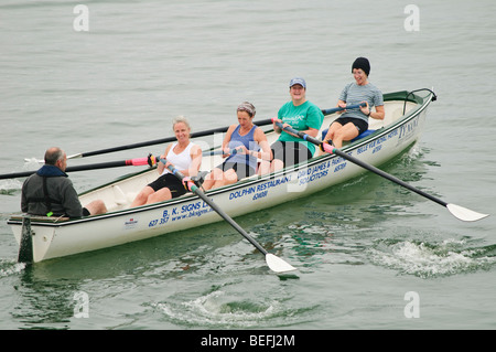 Quatre femmes aviron celtic longboat dans une course à Aberystwyth, Pays de Galles UK Banque D'Images